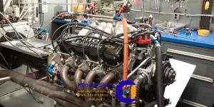 یک موتور مسابقهای قدرتمند که روی دستگاه داینو برای اندازهگیری دقیق توان و گشتاور در حال تست است. داینو تیونینگ به مهندسان و تیونرها اجازه میدهد تا عملکرد موتور را بهینه کنند و بهترین تنظیمات را برای آن پیدا کنند.